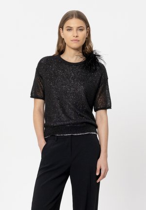 Schwarzer, kurzärmeliger Strickpullover mit strukturiertem Finish und metallischen Fäden. Besitzt eine dramatische Feder-Akzentuierung an der linken Schulter.