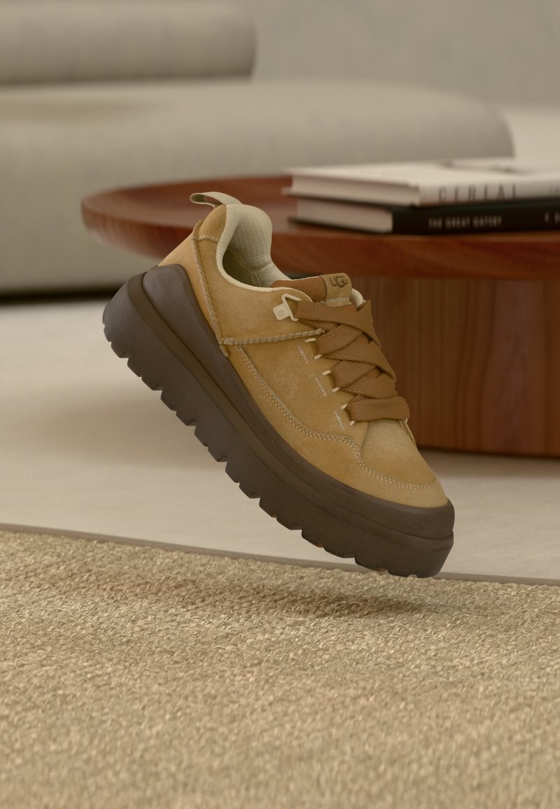 Ταν σουέντ αθλητικό παπούτσι με καφέ λαστιχένια σόλα, με υφασμένα κορδόνια και επένδυση στο κολάρο. Αναβαθμισμένος σχεδιασμός με διακριτική λεπτομέρεια εμπορικού σήματος.