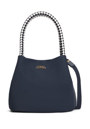 Tmavomodrá kabelka Tommy Hilfiger s čierno-bielymi pletenými rúčkami a odnímateľným ramenným popruhom.