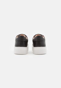 Sneakers in pelle nera con una superficie liscia, dotati di una suola in gomma bianca, forma rotonda e design minimalista. Nessun motivo o accento visibile.