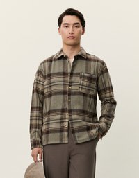 Πουκάμισο από flannel με κολάρο και κουμπιά σε καφέ και μπεζ καρό, με μία μόνο τσέπη στο στήθος και χαλαρή εφαρμογή. Μαλακή υφή από μάλλινο ύφασμα.