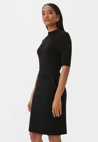 Schwarzes Kleid mit kurzen Ärmeln, taillierter Passform und einem knielangen Bleistiftrock. Glatte Textur in einfarbigem Design und minimalistischem Stil.