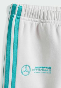 Weiße Sporthosen mit türkisfarbenen Streifen. Verfügt über einen elastischen Bund und gestickte Logos: AMG und Petronas Formula One Team.