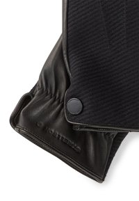 Zwarte leren handschoenen met een gestructureerde zwarte stoffen boord, voorzien van een knoopaccent en branding op het leer.