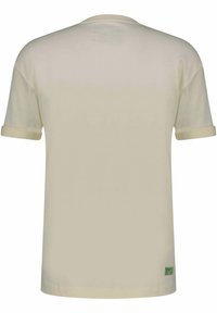 Beige short-sleeve T-shirt with folded cuffs, viewed from the back, featuring small green text near the bottom hem on the right side.