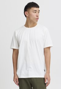 Hvit bomull crew-neck t-skjorte med korte ermer. Har en rett passform og liten merkeetikett på nederste del. Glatt tekstur.