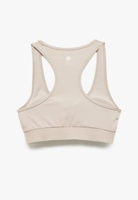 Beige sportsbh med et glat, strækbart materiale. Har racerback-design og en bred kant i bunden. Logo i midten bagpå.