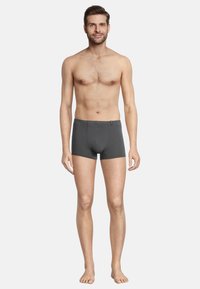Graue Baumwoll-Boxershorts mit enger Passform, ausgestattet mit einem Frontbeutel und einem Logo-Tag am Bund. Geschmeidige Textur und minimale Nähte.