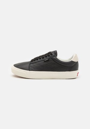 Zwarte leren sneaker met een gladde afwerking, witte rubberen zool, ronde neus en zwarte veters. Beschikt over een suède hielaccent en gestikte details.