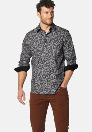 Geknöpftes Hemd in Grau mit einem schwarzen Paisleymuster. Verfügt über lange Ärmel, schwarze Manschetten und einen klassischen Kragen. Getragen mit braunen Hosen.