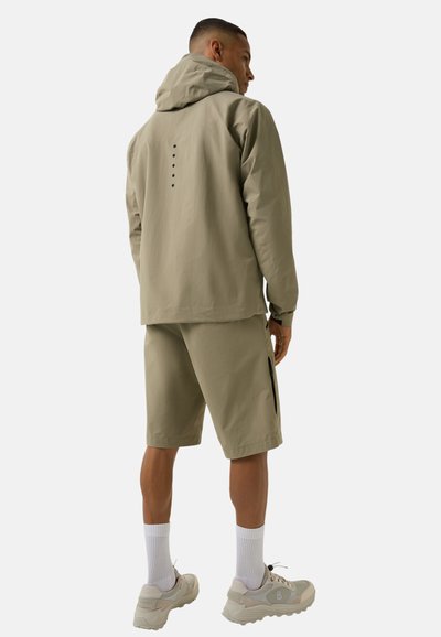 Light olive green hoodie with adjustable hood, featuring five vertical dots on the back. Paired with matching shorts and white socks.