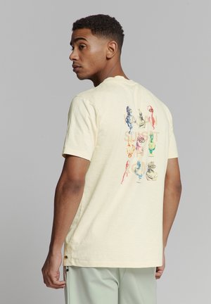 Kurzes, hellgelbes T-Shirt mit farbenfrohem Grafikdruck auf der Rückseite, der verschiedene stilisierte Büsten zeigt. Weicher, strukturierter Stoff.