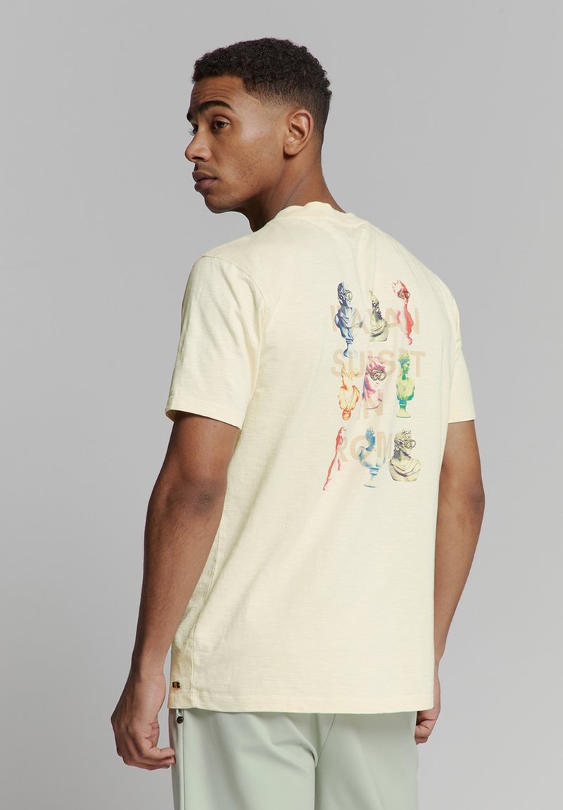 Korte mouwen, lichtgele t-shirt met een kleurrijke grafische print op de achterkant met verschillende gestileerde busten. Zachte, textuurstof.