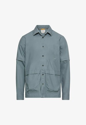 Lyseblå skjorte med knapper, spread-krave, korte ærmer, to forlommer og et lige snit. Fremstillet af et tekstureret stof.