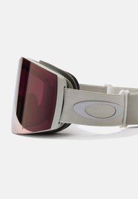 Snögoggles med en stor, böjd röd lins, vit plastram och grå elastisk rem med en logotyp och mjuk inredningsdämpning.