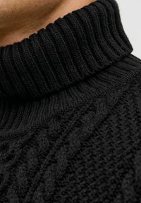 Zwarte kabelgebreide trui met een ribbelige col; zachte textuur; close-up weergave die gedetailleerde patronen en dik materiaal benadrukt.