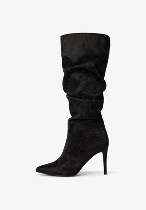 Stivale nero con tacco alto e punta affusolata, caratterizzato da un design arricciato e una texture con borchie, realizzato in un materiale morbido. Tacco a stiletto sottile.