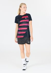 Sort og pink sports T-shirt med et mønster af vandrette striber, parret med en sort skort. FZ-logoet synligt på begge produkter, letvægtsmateriale.