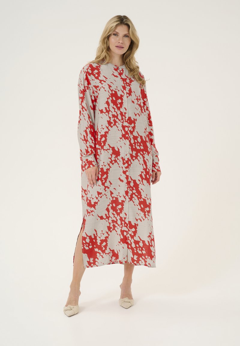Vestido de manga larga y botonadura en gris claro con un atrevido estampado abstracto en rojo y blanco. Presenta aberturas laterales y un fit relajado.