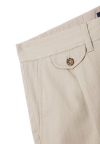 Pantalones beige con un patrón de espiga, con un frente plano, bolsillos laterales y un cierre de botón. Hechos de una tela texturizada.
