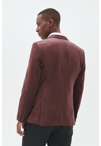 Burgunderfarbener, taillierter Blazer mit glatter Textur und satinierter Oberfläche. Bemerkenswerte Details sind ein einzelner Schlitz und knöpfbare Manschetten.