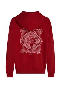 Červená mikina s kapucňou s veľkým bielym geometrickým vzorom a logom na chrbte, s rebrovanými manžetami a spodným lemom pre tesné priliehanie.