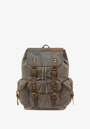 Zaino in tela cerata grigia con dettagli in pelle marrone, riportato con un flap a pieghe e molteplici tasche frontali chiuse da fibbie.