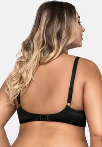 Reggiseno nero con spalline regolabili, tessuto liscio, bordo in pizzo lungo i lati e chiusura a gancio e occhiello sulla schiena.