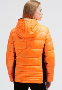 Padded jacket with a bright orange exterior, black side panels, and a hood. Features horizontal quilting and a zippered collar.