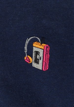 Borduursel van een cassettespelerontwerp met grijze, roze, oranje en zwarte elementen op een marineblauwe stoffen achtergrond. Inclusief een detail van een hoofdtelefoon.