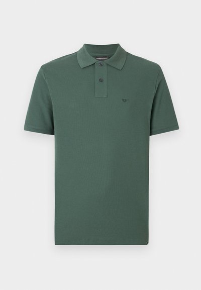 Polo vert en coton, avec un col, des manches courtes, une patte de boutonnage à trois boutons, et un petit logo en relief sur la poitrine.