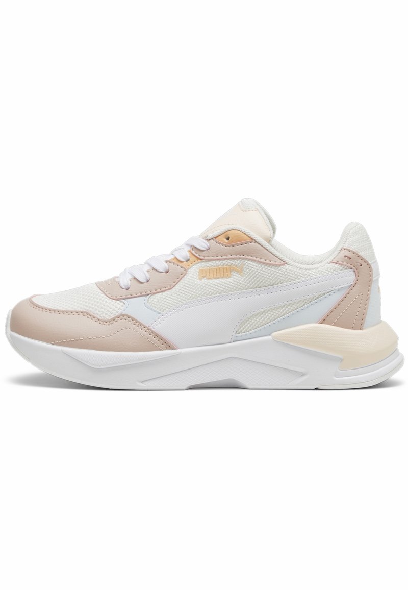 Sneaker blanche et beige de Puma avec des détails en maille et en cuir, fermeture à lacets et semelle rembourrée, présentée de côté sur un fond blanc.