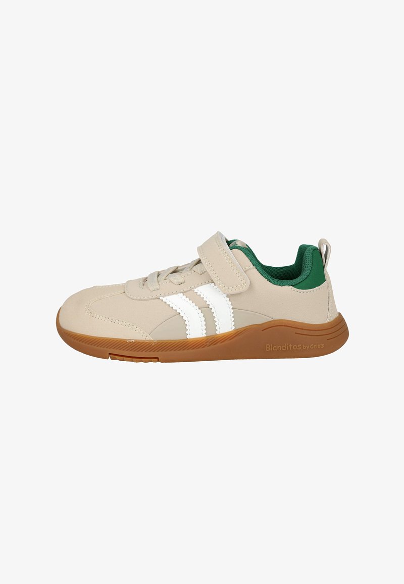 Zapatillas beige para niños con rayas blancas, forro interior verde, suela de goma marrón, cordones y una única correa de Velcro en el lado.