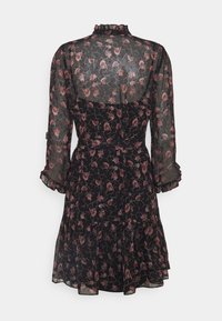 Robe noire à fleurs avec manches longues transparentes et col à volants. Comprend un corsage ajusté et une jupe à étages avec un motif floral rose.