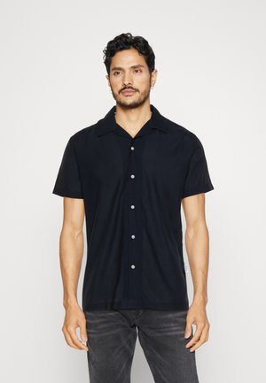 Camisa de manga corta con cuello en tejido de color azul marino oscuro, con un cierre de botones en la parte delantera con botones plateados y un corte relajado.
