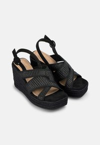 Sandali wedges neri con fasce in tessuto intrecciato, dettagli in suede e suola in espadrille texture. Cinghie regolabili per una vestibilità perfetta.