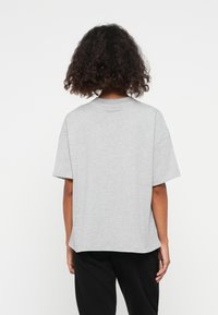 Gray short-sleeve t-shirt with a relaxed fit and a round neck. Made of soft cotton, it features a solid color and a simple, clean design.