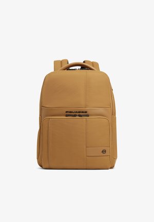 Sac à dos rectangulaire beige avec bretelles rembourrées, une poche zippée à l'avant et une poignée supérieure, doté de fermetures éclair noires et d'un détail logo.