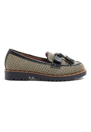 Zapato mocasín para mujer con tejido negro trenzado, ribete de cuero, detalle de borlas en la parte superior y suela de goma negra gruesa con patrón de relieve.