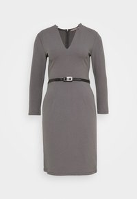 Šedé dlouhé šaty s výstřihem do V a černým páskem v pase. Hladká tkanina, přiléhavý střih, ke kolenům s zipovým uzávěrem na zadní straně.