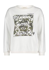 Sudadera blanca de manga larga, con un diseño gráfico texturizado en verde y negro, y un texto que dice "TOMA TUS SUEÑOS EN SERIO".