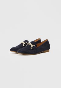 Navy suede loafers with a pointed toe, flat heel, and gold-colored hardware detail on the front. Smooth texture with a minimalist design.