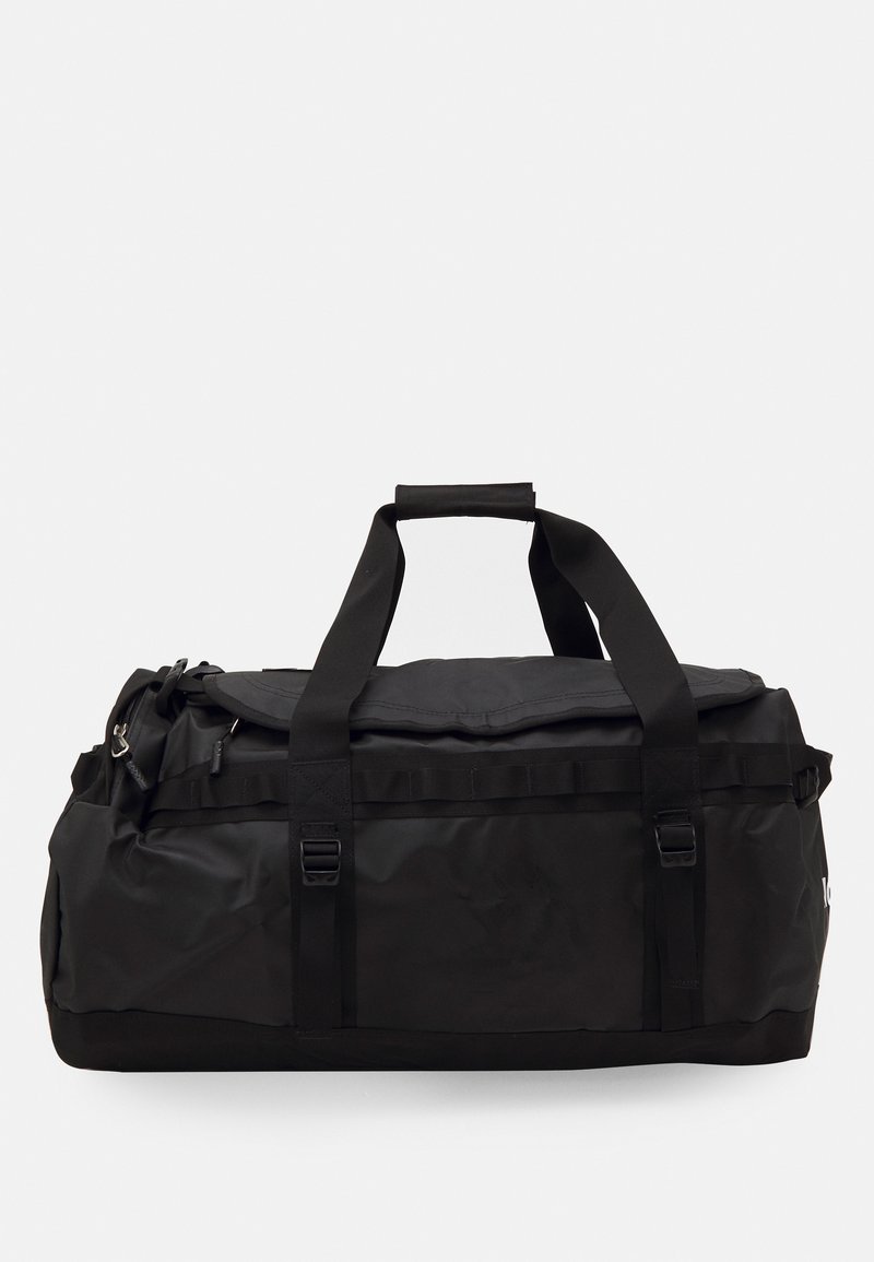 Sac de sport noir en tissu résistant, doté de poignées doubles, d'une fermeture zippée sur le dessus et de clips latéraux pour sécuriser les objets.