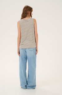 Stribet tanktop i beige og hvid, parret med lyseblå vide bukser. Toppen har en rund halsudskæring og er uden ærmer.
