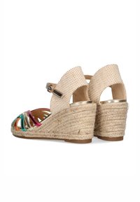 Sandalias de cuña con parte superior de tejido beige trenzado y tiras metálicas multicolores. Presenta un tacón envuelto en yute y una correa en el tobillo ajustable.