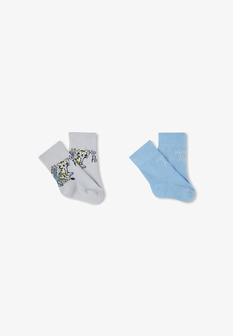 Une paire de chaussettes : grises claires avec un design de tigre ; bleues avec du texte. Les deux sont en coton, avec des bords côtelés et une construction sans couture au niveau des orteils.