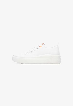 Zapatilla deportiva de lona blanca con una suela plataforma gruesa. Presenta una puntera redonda, seis ojales y un acento naranja cerca de los cordones. Textura suave.