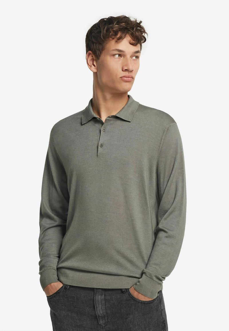 Långärmad polo i dämpad olivgrön, med klassisk krage, treknappars knäppning och subtilt texturerad tyg.