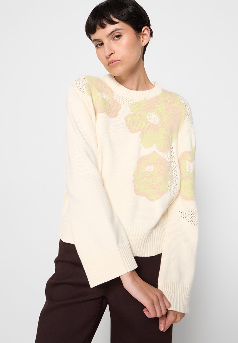 Cremfarbener Strickpullover mit floralen Mustern in Hellgrün und Beige, mit Rundhalsausschnitt und weiten Ärmeln mit strukturierten Akzenten.