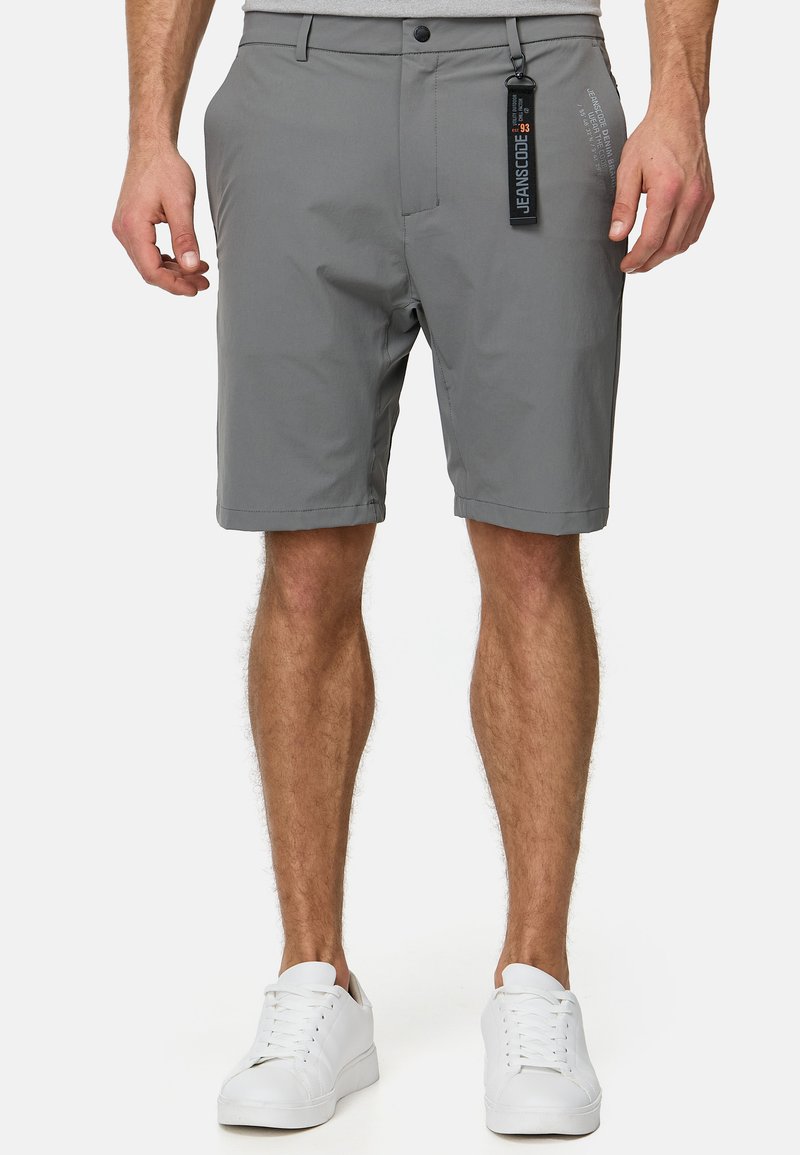 Gray shorts made from lightweight fabric, featuring a flat front, side pockets, and a small logo detail on the left leg. Pair with white sneakers.